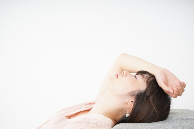 頭痛がひどく横たわる女性
